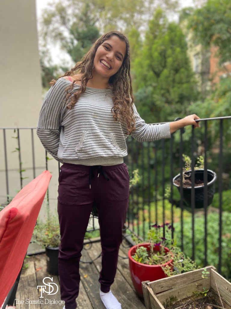 Me standing on the deck over my backyard, smiling. There are trees behind me. My logo is in the bottom left corner in white.